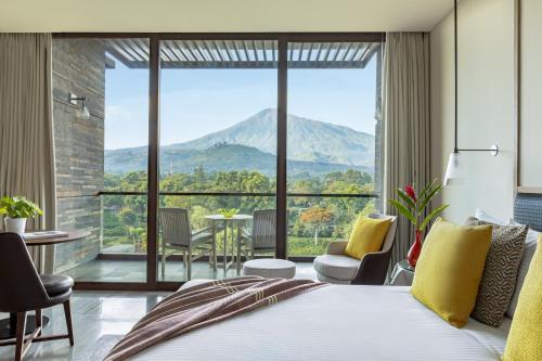 a bedroom with a bed and a view of mountains at Gran Melia Arusha in Arusha