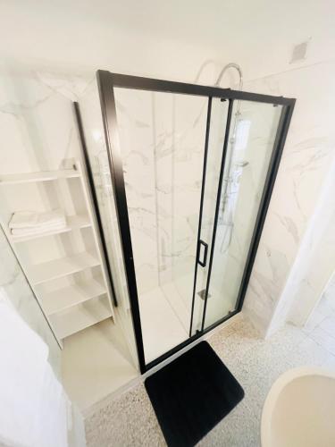 une douche dans une salle de bain avec une porte vitrée dans l'établissement Au Pied Des Remparts, à Avignon