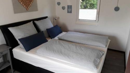 a bedroom with two beds with blue pillows at Ferienhaus in Kirburg mit Großer Terrasse in Kirburg