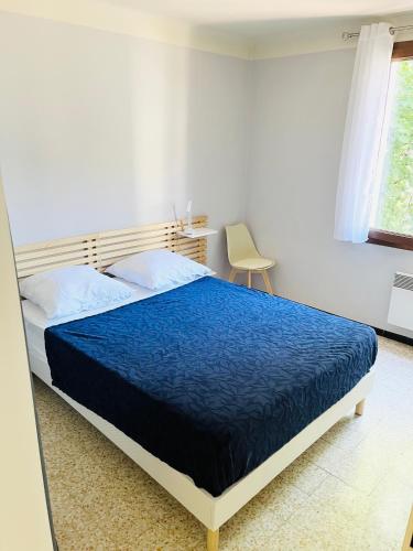 une chambre avec un lit avec une couette bleue dans l'établissement Au Pied Des Remparts, à Avignon