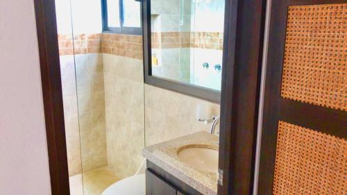a bathroom with a sink and a toilet and a mirror at Espectacular Casa de Descanso en Anapoima in Anapoima