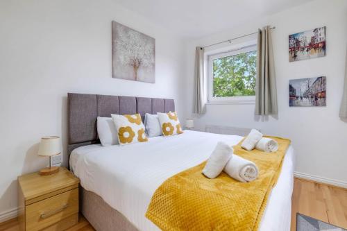 a bedroom with a large bed with towels on it at Delightful 4 bedroom House Thamesmead West From 360stays in North Woolwich