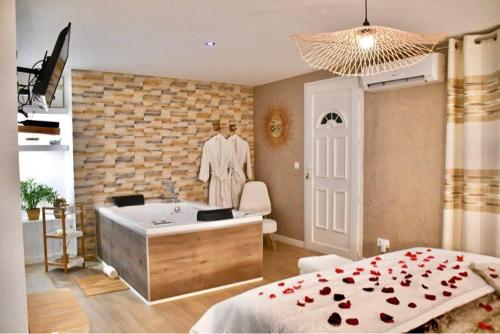 a bedroom with a bed and a bath tub at Les Nuits d Olympe - Suite & Spa privatif in Lacoste