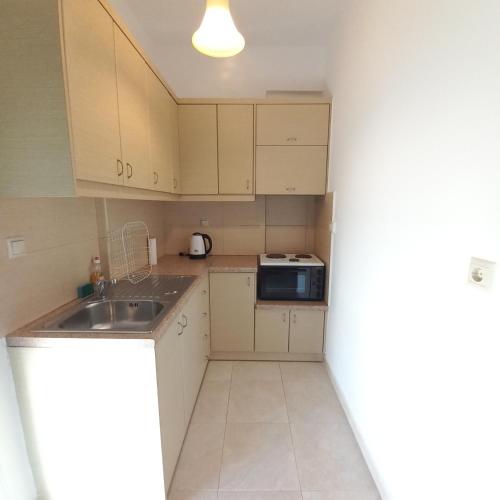 a small kitchen with a sink and a microwave at Central Rooms in Makry Gialos