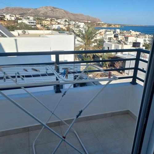a balcony with a view of a city and the ocean at Central Rooms in Makry Gialos
