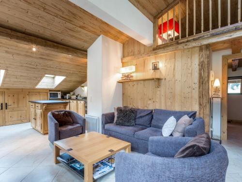 un salon avec un canapé bleu et une table dans l'établissement Chalet moderne avec grands espaces, garage et WIFI - FR-1-304-131, à La Clusaz