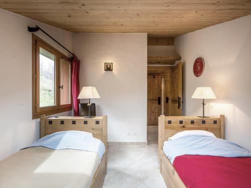 une chambre avec deux lits et une fenêtre dans l'établissement Chalet moderne avec grands espaces, garage et WIFI - FR-1-304-131, à La Clusaz