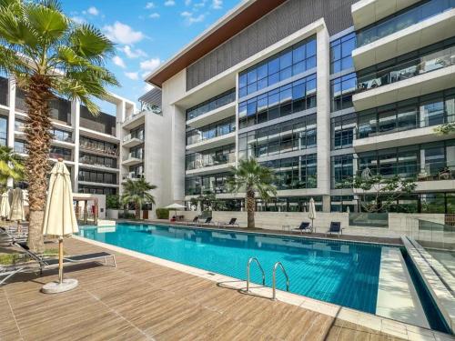 an apartment building with a swimming pool and palm trees at Luxury Apartment with Pool, Patio & Gym in City Walk By ĀYA Boutique in Dubai