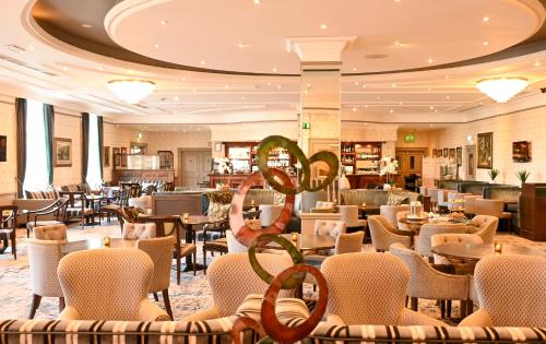a hotel lobby with tables and chairs and a restaurant at Mount Wolseley Hotel Spa & Golf Resort in Tullow