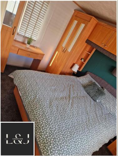 Un dormitorio con una cama y una ventana en L&J Caravan Skegness, en Chapel St. Leonards