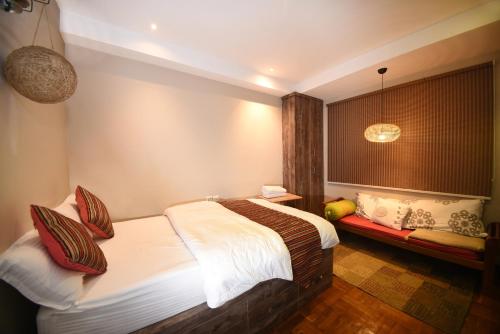 a bedroom with a bed and a bench in it at Mums Homestay & Studio Apartments in Kathmandu
