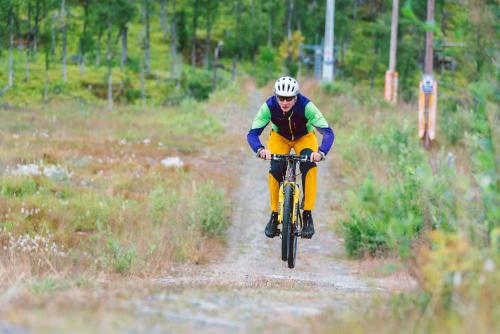 a man riding a bike down a dirt road at Målselv Fjellandsby Apartments in Bardufoss