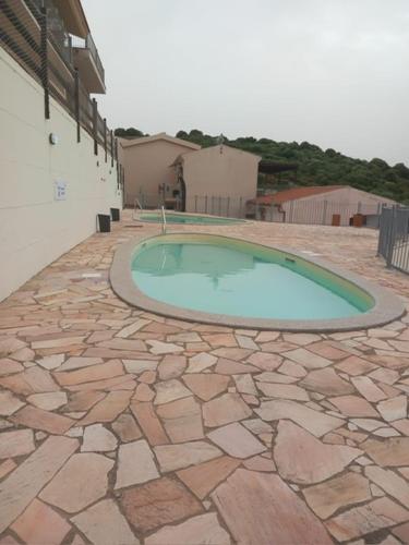 a small swimming pool on a stone patio at Appartamento trilocale vista mare FT4 in Cascabraga