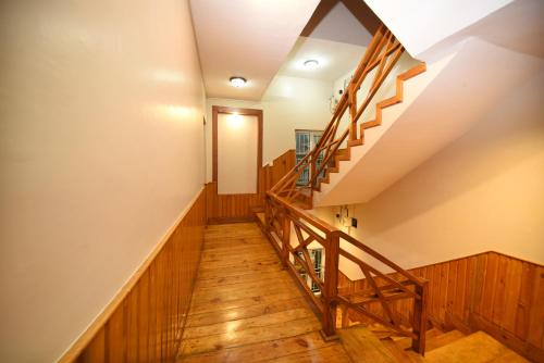 a staircase in a house with wooden flooring and wooden railing at Mums Homestay & Studio Apartments in Kathmandu