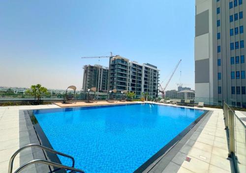 a large swimming pool on the roof of a building at Stylish 2BR Apartment at Dubai Hills with Pool Access By ĀYA Boutique in Dubai