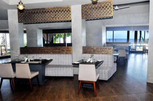 a restaurant with tables and chairs and a view of the ocean at Sinclairs Bayview in Port Blair