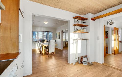 a kitchen and dining room with a wooden ceiling at Lovely Home In Thyborøn With Kitchen in Thyborøn