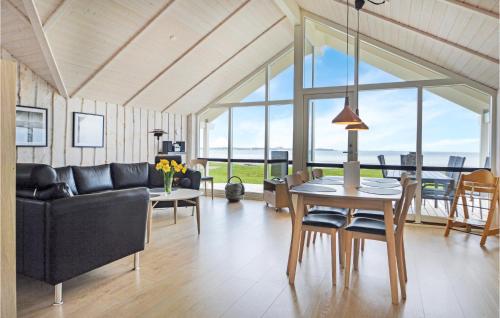 a living room with a couch and a table with chairs at Three-Bedroom Holiday Home In Sjolund in Sjølund