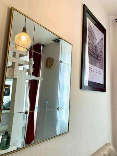 un miroir accroché au mur dans une pièce dans l'établissement Studio cosy jardin des plantes, à Toulouse