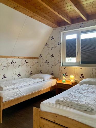 two twin beds in a room with a window at Gemütliches Haus De Druif mit Balkon in Anjum