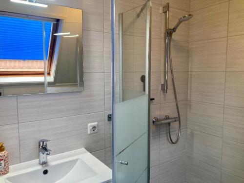 a bathroom with a sink and a shower at Gemütliches Haus De Druif mit Balkon in Anjum