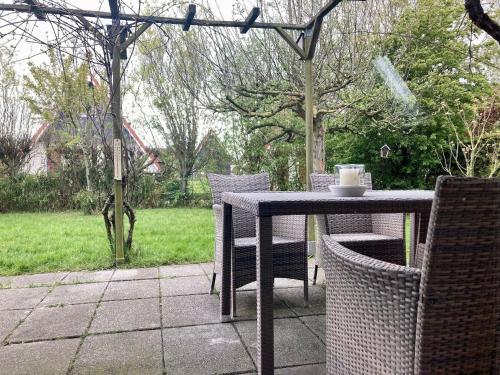 an outdoor table with chairs and a cup of coffee on it at Gemütliches Haus De Druif mit Balkon in Anjum
