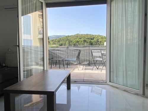une pièce avec une table et des chaises sur un balcon dans l'établissement Appartement Cosy avec Piscine, à Ollioules