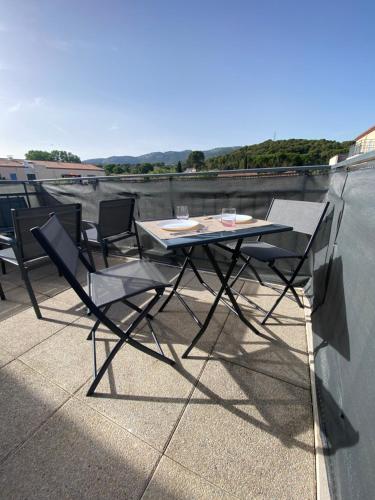 une table et des chaises au-dessus du toit dans l'établissement Appartement Cosy avec Piscine, à Ollioules