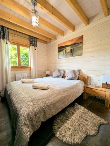 une chambre avec un grand lit dans une pièce en bois dans l'établissement Chalet Sauna jacuzzi 6 personnes, à La Bresse