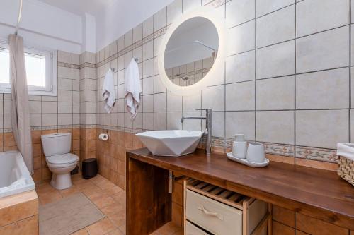 ein Badezimmer mit Waschbecken, Toilette und Spiegel in der Unterkunft Mi Casa - Serene Garden Retreat, 2 bedroom house in Korfu-Stadt