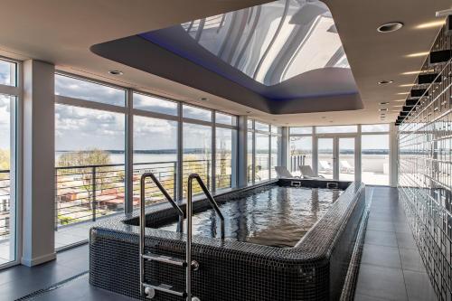 jacuzzi w pokoju z oknami w obiekcie Molo Park Aparthotel w mieście Mielno