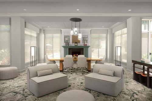 a living room with a table and chairs and a fireplace at Hilton Garden Inn Gainesville in Gainesville