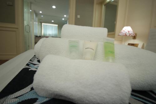 a pile of towels sitting on top of a bed at Park Avenue Hotel Sungai Petani in Sungai Petani