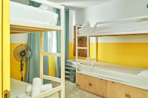 a room with two bunk beds and a fan at LOFT HOSTAL Group in Lloret de Mar