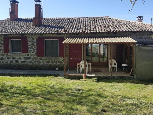 une petite maison avec 2 chaises et une terrasse couverte dans l'établissement Maison typique de Haute Loire de 1782, à Salettes