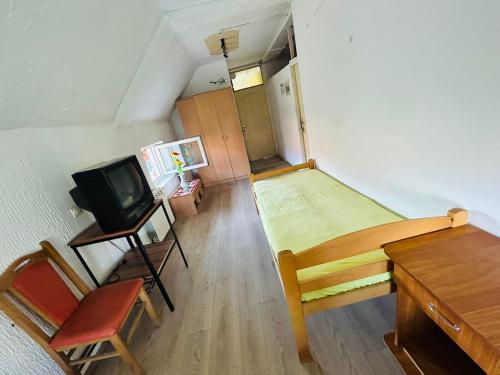 a small room with a bed and a desk and a tv at Rooms for rent "SARA" in Belgrade