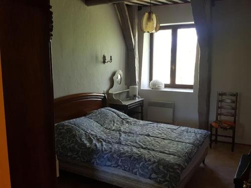 une chambre avec un lit et une fenêtre dans l'établissement Maison typique de Haute Loire de 1782, à Salettes