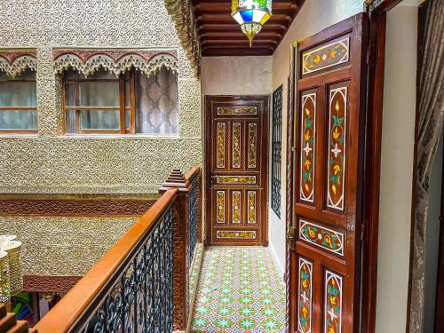 an entrance to a house with wooden doors and stairs at Riad el wazania in Rabat