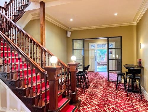 シドニーにあるTempe Hotel Sydneyの椅子とテーブル付きの客室内の階段