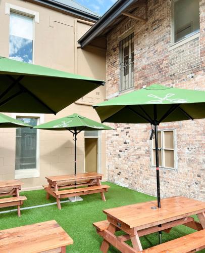 シドニーにあるTempe Hotel Sydneyの建物前の傘付きピクニックテーブル