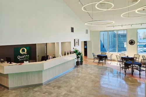 a lobby with a waiting area with tables and chairs at Quality Inn & Suites in Gatineau