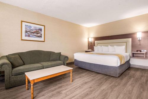 a hotel room with a bed and a couch at Quality Inn & Suites in Gatineau