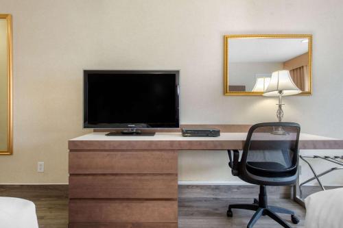 a desk with a television and a chair in a room at Quality Inn & Suites in Gatineau