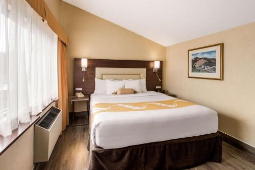 a hotel room with a large bed and a window at Quality Inn & Suites in Gatineau