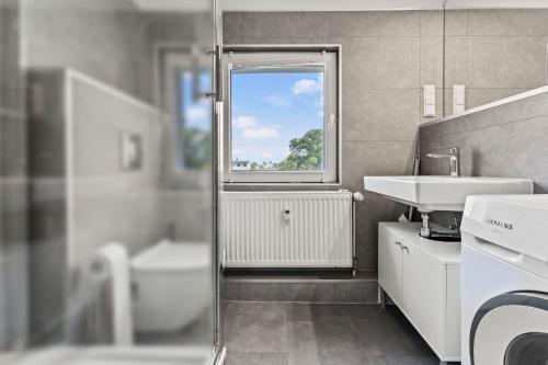 a bathroom with a sink and a toilet and a window at Chic & Modern Apartments in Eberswalde in Eberswalde