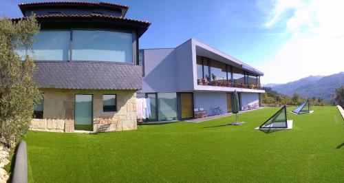 une grande maison avec une pelouse verte en face de celle-ci dans l'établissement ArsDurium Douro hotel, à Cinfães