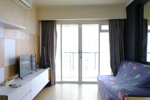 a living room with a tv and a couch in a room at Strategic and Comfortable 2BR Apartement at Gateway Pasteur By Travelio in Bandung