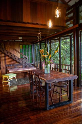 a wooden table with chairs and a vase of flowers on it at The Dusun in Seremban