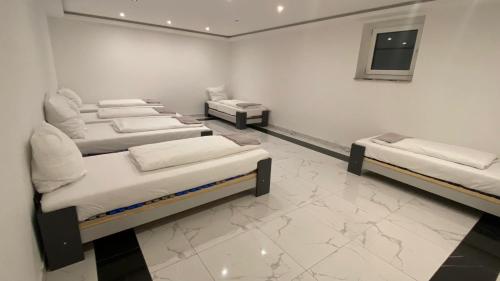 a room with four beds and a tv in it at Hotel Business Bay das ehemalige Staycation Hotel in Sindelfingen