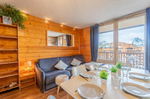 un salon avec une table et un canapé dans l'établissement Ski In-Out - Heart of Val Thorens Warm-Hearted Apartment, WiFi 165, à Val Thorens